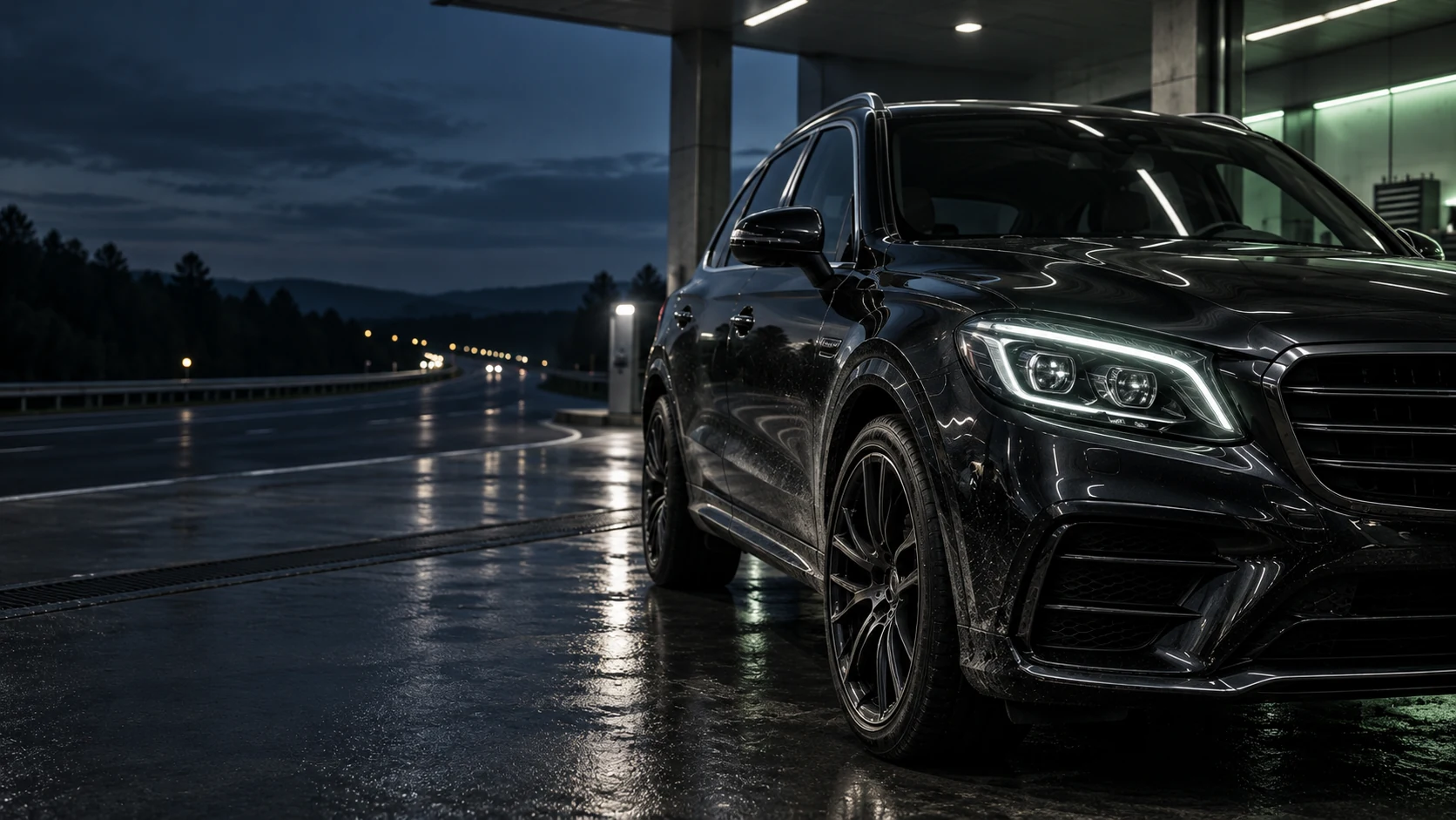 Чёрный SUV с включённой передней оптикой у трассы после поездки